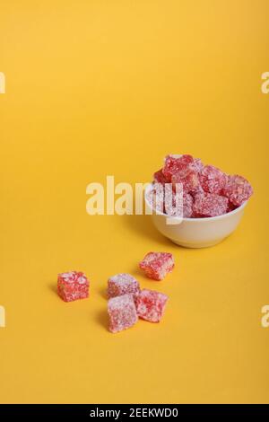 Una ciotola di rahat Lakoum isolato su sfondo giallo. Dolce concetto turco. L'immagine contiene spazio per la copia Foto Stock