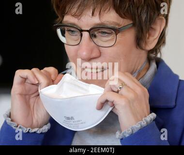 Nettersheim, Germania. 16 Feb 2021. Annegret Kramp-Karrenbauer (CDU), Ministro federale della difesa, toglie la sua protezione dal naso a bocca dopo la sua visita al Kommunales Impfzentrum Euskirchen. Credit: Liver Berg/dpa/Alamy Live News Foto Stock