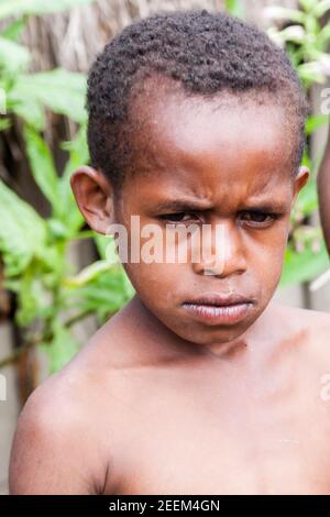 Wamena, Indonesia - 9 gennaio 2010: Portret del bambino della tribù Dani. Ragazzo che guarda la macchina fotografica, Papua Nuova Guinea. Foto Stock