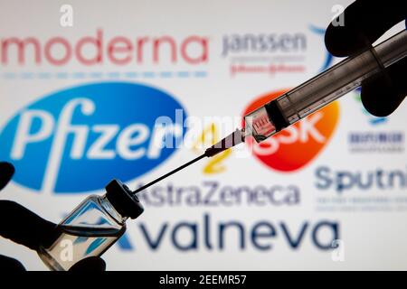 OXFORD, UK - Febbraio 2020: Siringa di vaccino davanti al logo del vaccino Covid Foto Stock