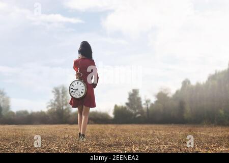 momento surreale di una donna che sta camminando verso di lei destino con il peso del tempo che passa Foto Stock