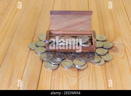 Monete d'argento in una cassa di tesoro in legno. Concetto di fare soldi - affari e così via. Foto Stock