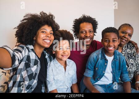 Famiglia multigenerazionale che prende selfie a casa. Foto Stock