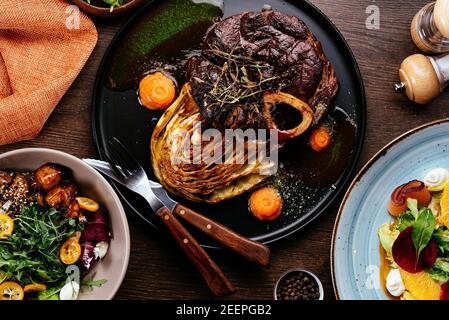 Bistecca alla griglia su ardesia che serve piatto con erbe vegetali e. spezie Foto Stock