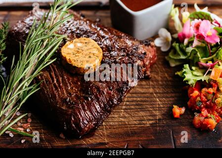 Bistecca alla griglia su ardesia che serve piatto con erbe vegetali e. spezie Foto Stock