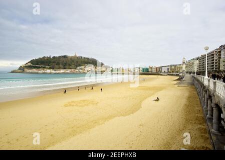 San Sebastian, Spagna - 02 2020. Pochi escursionisti sulla spiaggia di la Concha a San Sebastian durante l'epidemia di Covid-19 Foto Stock