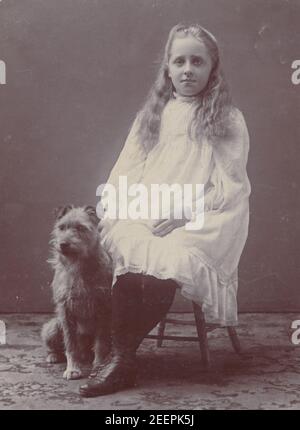 Cartolina fotografica edoardiana vintage 1906 di una giovane ragazza Sat con il suo cane da compagnia chiamato Joe. Foto Stock