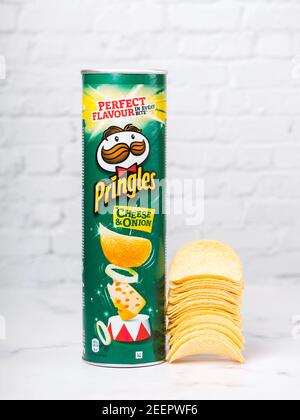 Lattina di formaggio Pringles e cipolla. Cartone con patatine Pringles su un tavolo bianco Foto Stock