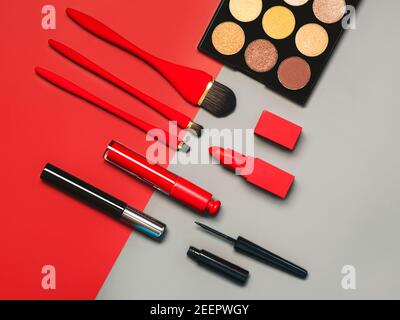 Cosmetici diversi make-up femminile e accessori su un grigio e. Red background.Make Up Beauty Fashion Concept Foto Stock
