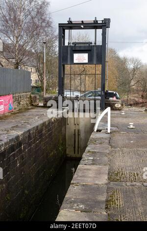 Una vista della ghigliottina Lock 24E sul canale stretto di Huddersfield, Slaithwaite, West Yorkshire, Regno Unito Foto Stock