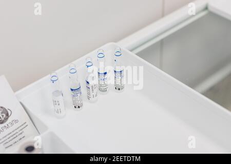 Omsk, Russia, febbraio 9,2021. Vaccino noto come Sputnik V.Ampules con lettere russe tradotte come Gam-COVID-Vac.First component.Glass fiale mediche Foto Stock