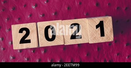 2021 nuovo anno su cubetti di legno su fondo di pelle rossa. Concetto di radulazione NY. Foto Stock