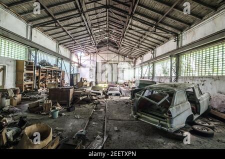 abbandonata grande officina con auto Foto Stock