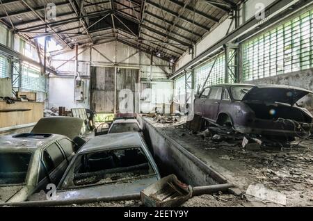 molte vecchie auto abbandonate in una sala Foto Stock