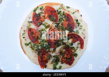 L'Uttapam, conosciuto anche come Uttapa, è un pancake indiano saporito. Condimento di pomodoro, coriandolo e cipolla a fette. Questo è l'uttapam di pomodoro Foto Stock