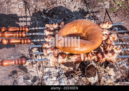 Grigliate la carne su calici caldi e spiedini. Il pane di lavasch viene riscaldato per il kebab. Cibo picnic in natura. Foto Stock