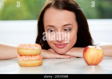 Ragazza rendendo la scelta tra un sano/alimenti dannosi per la salute Foto Stock