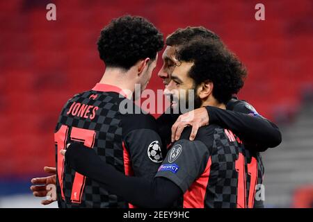 Budapest, Ungheria. 16 Feb 2021. Calcio: Champions League, turno di knockout, turno di 16, prima tappa, RB Leipzig - Liverpool FC alla Puskas Arena. Mohamed Salah (r) di Liverpool festeggia con Curtis Jones (l) e Roberto Firmino (m) di Liverpool dopo aver segnato l'obiettivo 0:1. Credit: Marton Monus/dpa/Alamy Live News Foto Stock