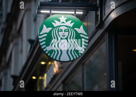 Cartello con logo Starbucks verde illuminato di notte Foto Stock