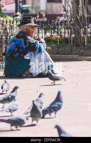 SUCRE, BOLIVIA - 19 LUGLIO 2016: Una donna anziana si trova sul pavimento della piazza principale di Sucre, Bolivia. Situato in una valle circondata da montagne, il Th Foto Stock