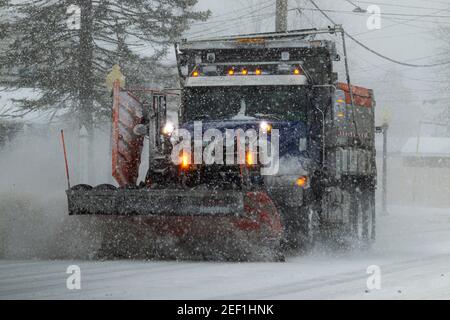 Babylon, New York, USA - 1 febbraio 2021: Un aratro da neve sta schiarendo, levigando e salendo la strada durante una bizzard in Babylon Village Long Island New Yo Foto Stock