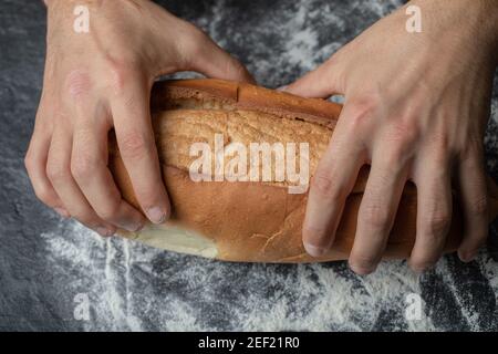 Mani femminili che tengono il pane appena sfornato, closeup Foto Stock