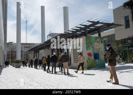 Austin, Texas, Stati Uniti. 16 Feb 2021. Austin, Texas, 16 febbraio 2021: I residenti di Austin in zona nevicata si allineano per fare acquisti presso un negozio di alimentari Trader Joe nel quartiere alla moda di Seaholm, mentre il Texas fatica a riprendersi da una tempesta di neve storica e dalle brutali temperature fredde. La maggior parte delle aziende sarà chiusa tutta la settimana a causa della tempesta. Credit: Bob Daemmrich/ZUMA Wire/Alamy Live News Foto Stock