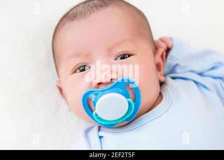 Adorabile bambino neonato con manichino sdraiato sul letto bianco foglio - vista dall'alto Foto Stock