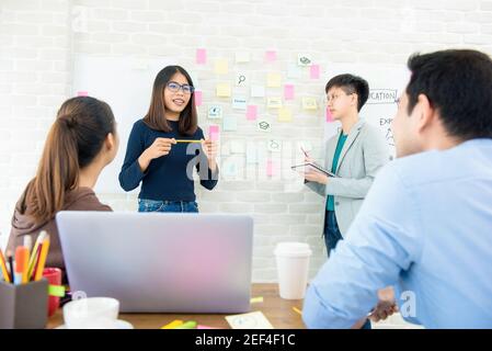 Gruppo di studentesse asiatiche che presentano e discutono il progetto in in aula Foto Stock