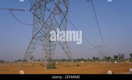 10 febbraio 2021 - Sikar, Jaipur, India. Palo di ferro triangolare posto a terra per l'alimentazione di energia. Linee elettriche sul mozzo della trasmissione di potenza. Tecnica Foto Stock