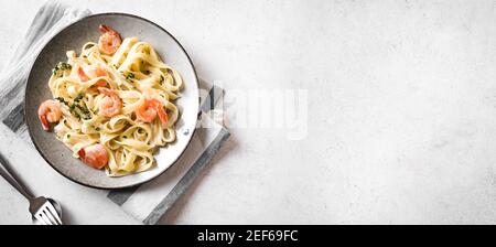 Pasta di fetticcine di gamberetti. Pasta italiana con gamberi e crema salsa alfredo, vista dall'alto, spazio copia. Foto Stock