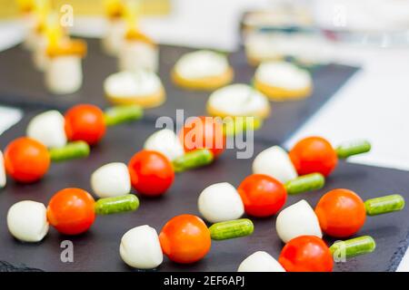 Deliziosi dessert sul tavolo da banchetto. Antipasti di uova e pomodoro su spiedini Foto Stock