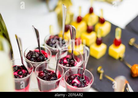 Deliziosi dessert sul tavolo da banchetto. Frutta, gelato con marmellata, antipasto di formaggio su spiedini Foto Stock