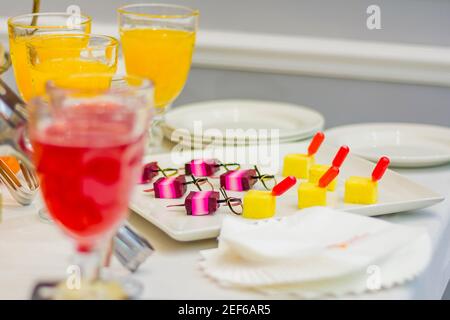 Deliziosi dessert sul tavolo da banchetto. Frutta, cocktail, succhi di frutta, antipasto di formaggio sugli spiedini Foto Stock