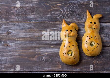 Polpettine con cipolle verdi e uova, in forma di coniglio su un tavolo di legno, spazio libero. Deliziosa colazione fatta in casa per bambini Foto Stock