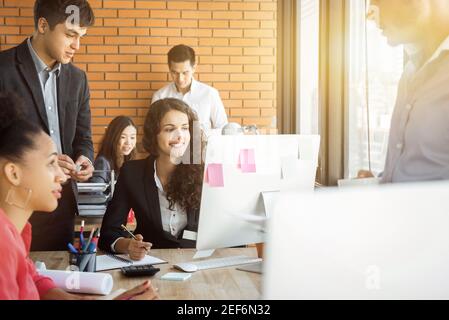 Team aziendale informale di Multiethnics in uno spazio di lavoro congiunto Foto Stock