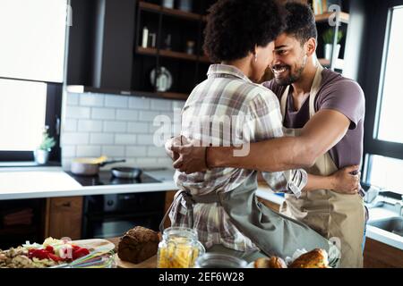 Felice coppia giovane cucinare insieme nella cucina di casa. Foto Stock