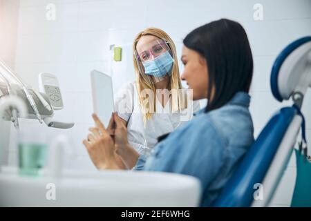 Medico sincero che guarda la sua paziente felice Foto Stock