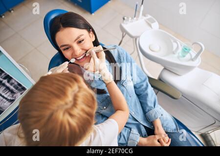 Foto focalizzata sulla donna che ascolta la sua stomatologa Foto Stock