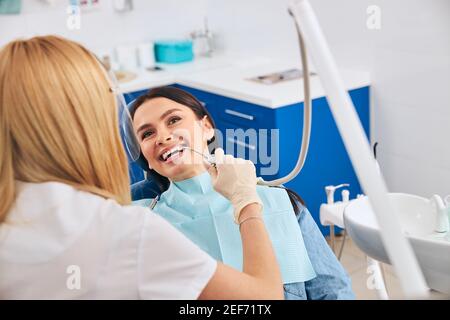 Dentista competente che lavora in un moderno gabinetto di stomatologia Foto Stock