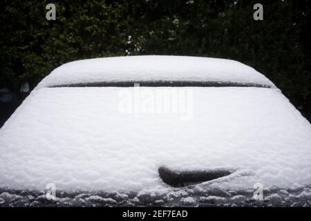 Primo piano del tergicristallo congelato e del parabrezza posteriore di un'auto dopo una tempesta invernale con neve e pioggia ghiacciata. Foto Stock