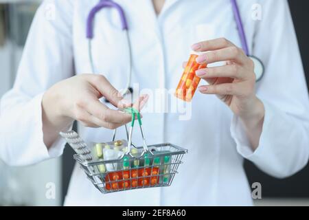 Il medico tiene il cestino delle pillole in mano Foto Stock