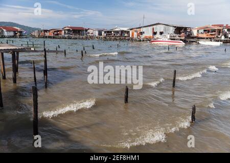 Povere case di legno e passerelle su palafitte. Paesaggio costiero del di Kota Kinabalu, Malesia Foto Stock