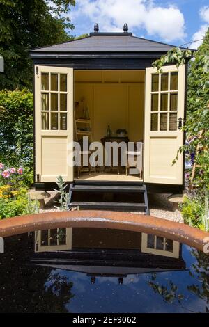 Un piccolo cottage inglese giardino con Summerhouse Shepherds Hut - lavorare da casa ufficio cabina - acqua caratteristica stagno - Londra UK - elegante capanna da giardino Foto Stock