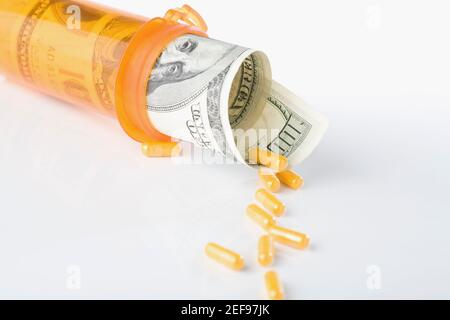 Rotolo delle fatture del dollaro degli Stati Uniti cento all'interno di una pillola flacone con capsula Foto Stock