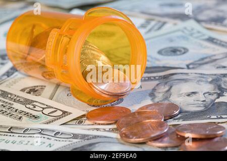 Close up di monete e bottiglia di pillola sulla valuta di carta degli Stati Uniti Foto Stock