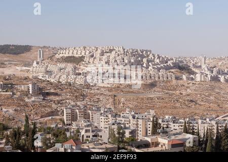 Har Homa, insediamento ebraico situato in cima alla collina, visto da Betlemme, Palestina Foto Stock