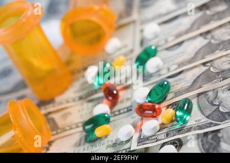 Close up di farmaci e bottiglie di pillole sulla valuta cartacea degli Stati Uniti Foto Stock
