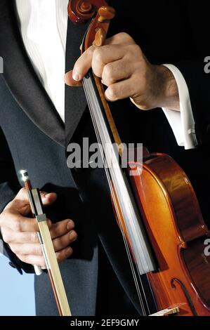Vista in sezione intermedia di un musicista che tiene un violino e. un arco Foto Stock