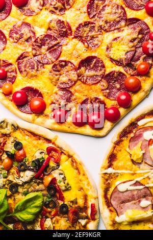 diverse pizze di vario genere in assortimento con basilico verde, primo piano Foto Stock